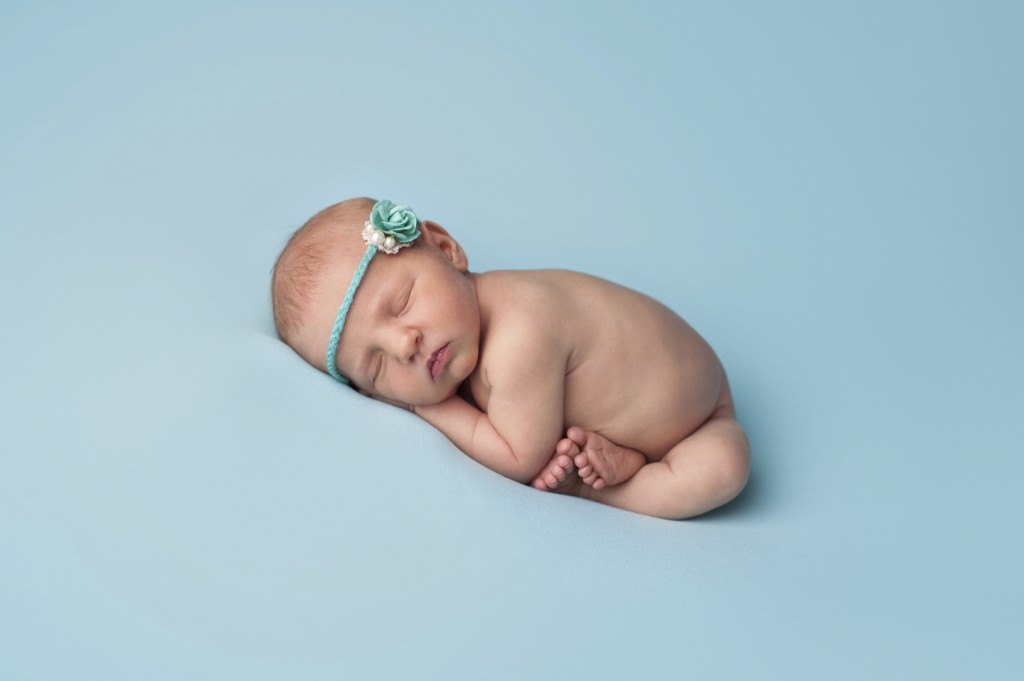 Sleeping Newborn Baby Girl Wearing a Blue Rose Headband