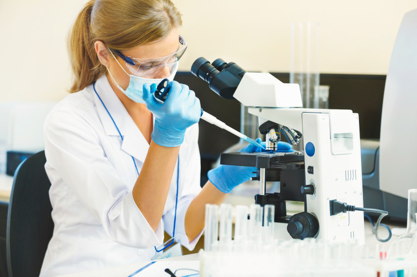 Female scientist adding a sample to a microscope in a lab