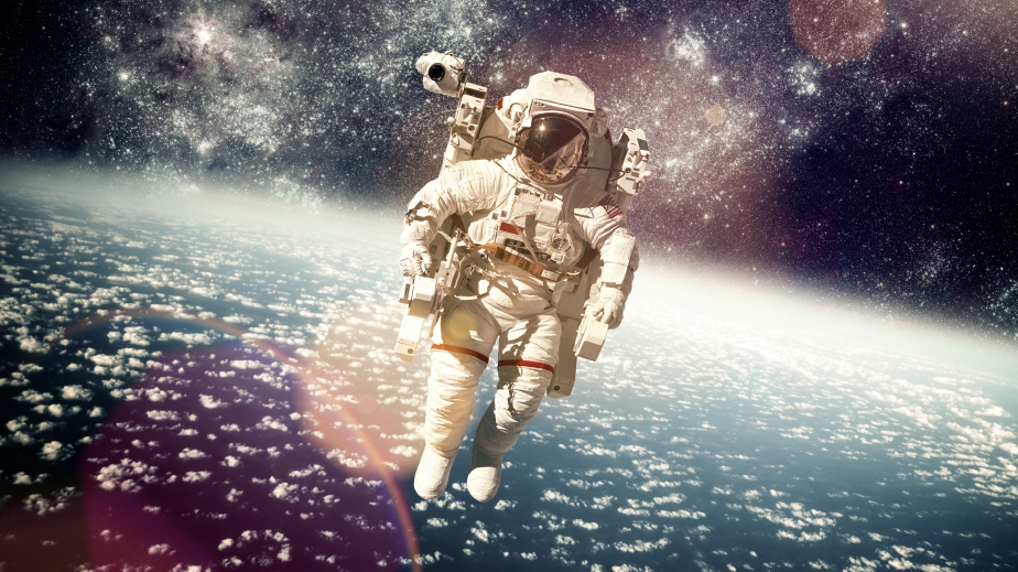 Astronaught in a space suit with a photoshopped galaxy as the background