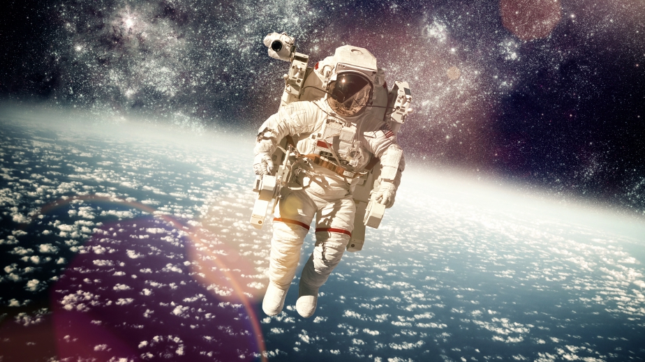 Astronaught in a space suit with a photoshopped galaxy as the background