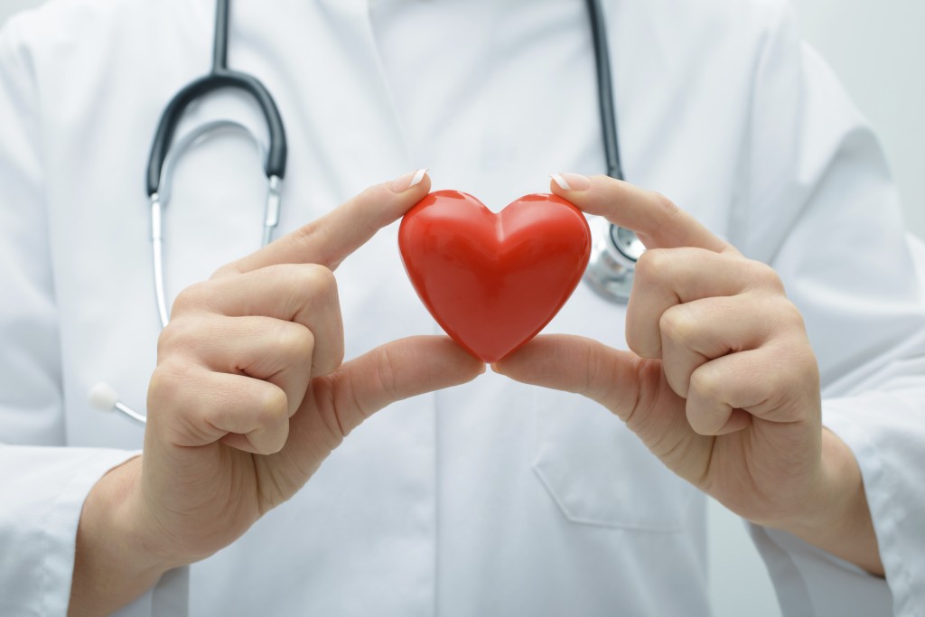 Female doctor with the stethoscope holding heart