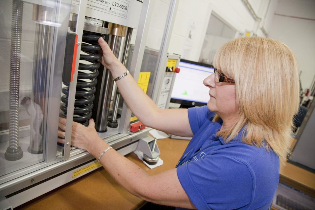 woman testing spring resistance on a machine