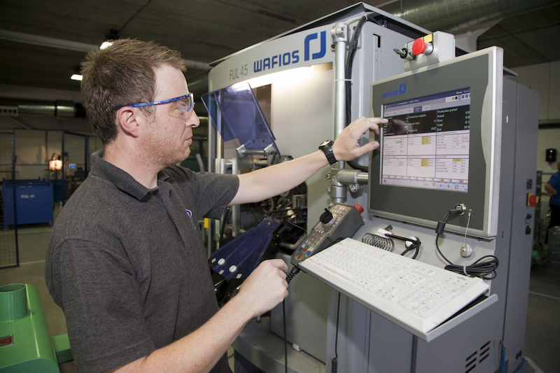 man operating a cnc coiling machine